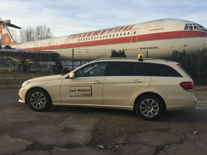 Mercedes Taxi vor Flugzeug